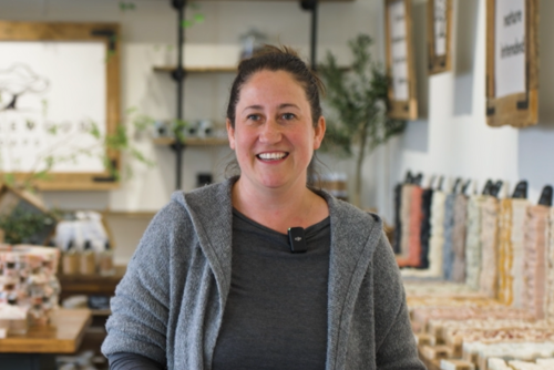 Caucasian woman with brown hair tied up standing in a store